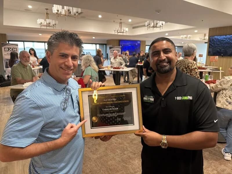 Dagan Martinez-Vargas presenting a Play the Room 90-Day Networker Certification to a graduate at a networking event