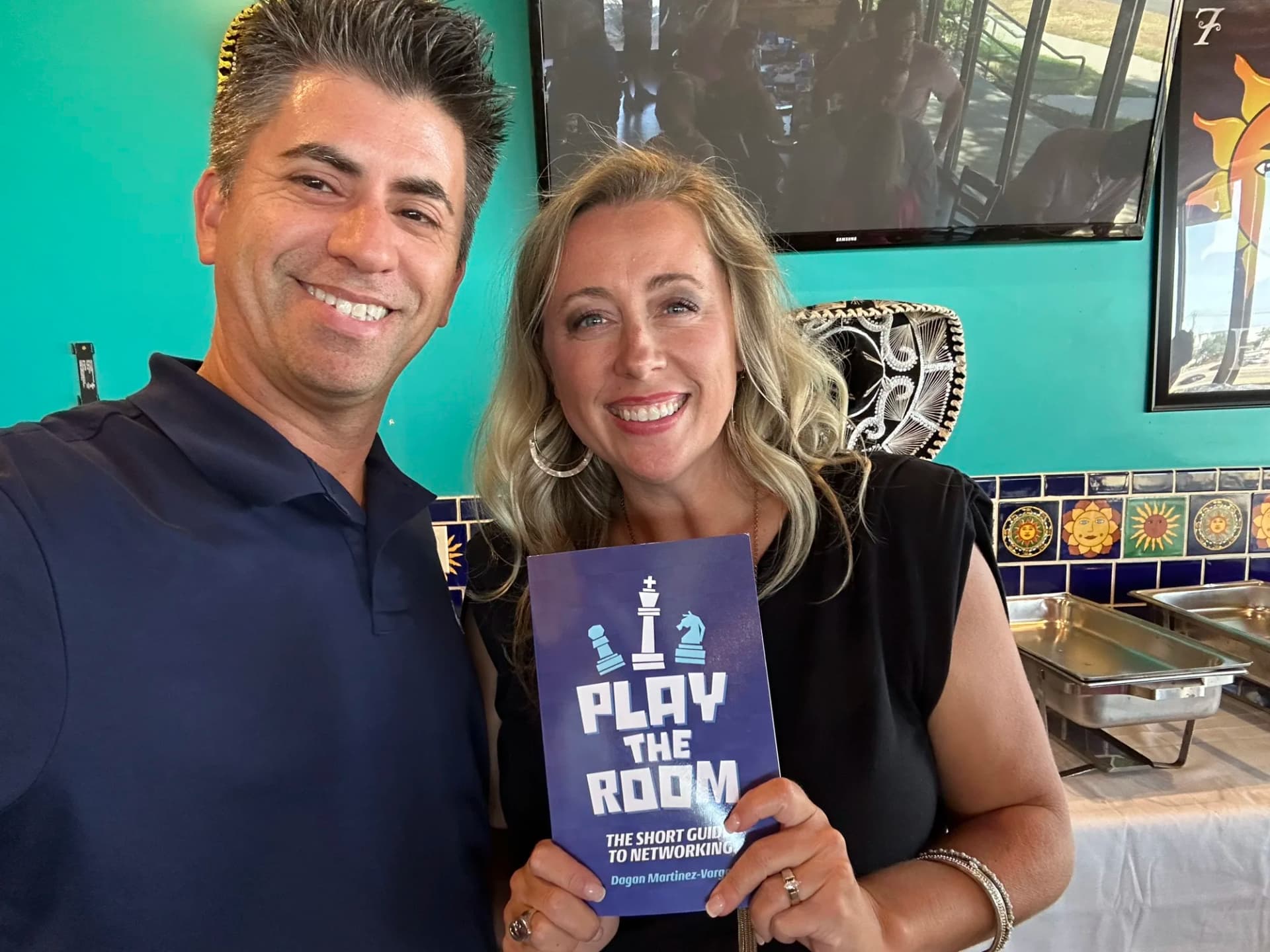 Dagan Martinez-Vargas with a reader holding a copy of Play the Room
