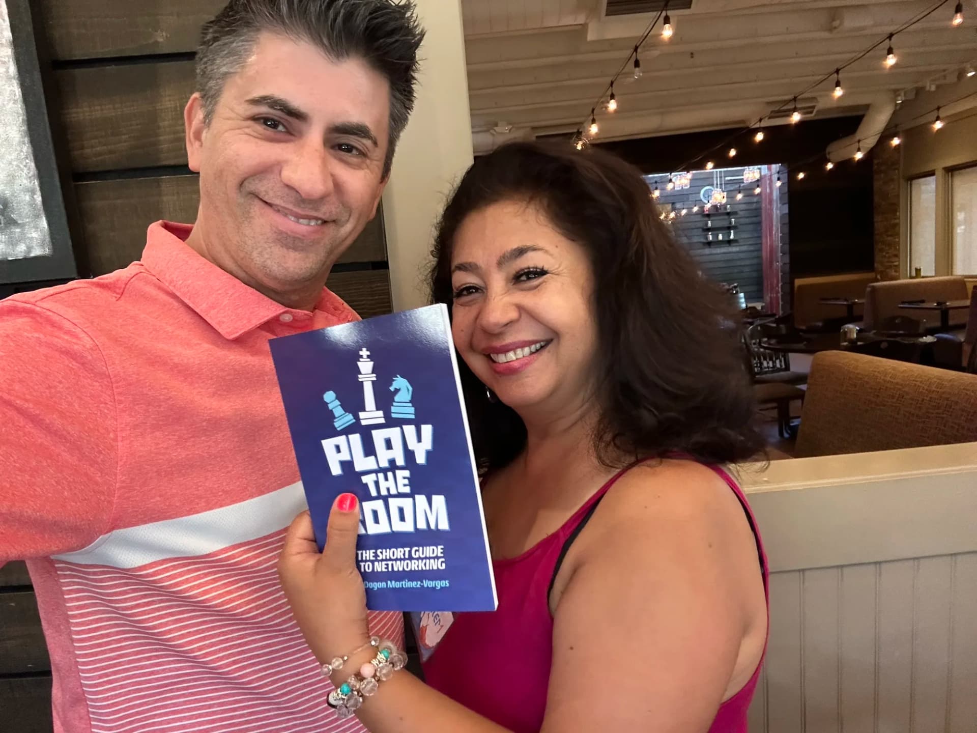 Dagan Martinez-Vargas with a reader holding a copy of Play the Room