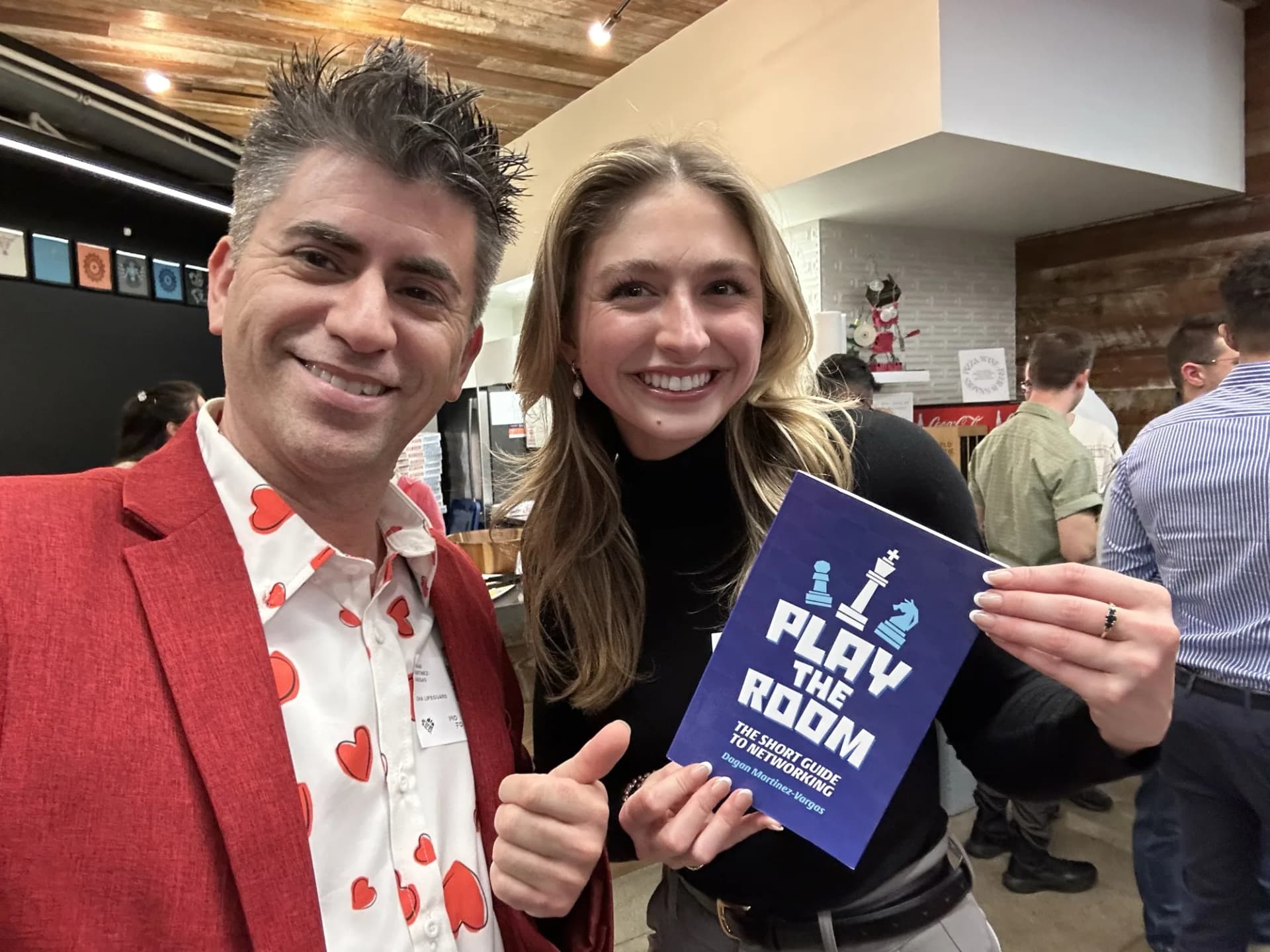 Dagan Martinez-Vargas with a reader holding a copy of Play the Room
