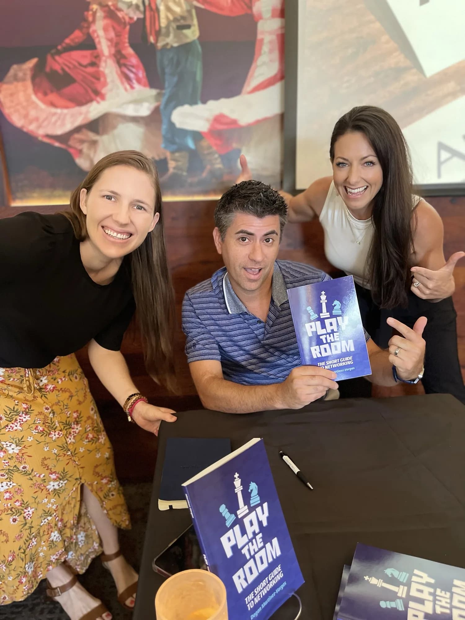 Dagan Martinez-Vargas with a reader holding a copy of Play the Room